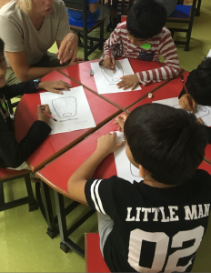 Sandra sitting at a table educating children in India
