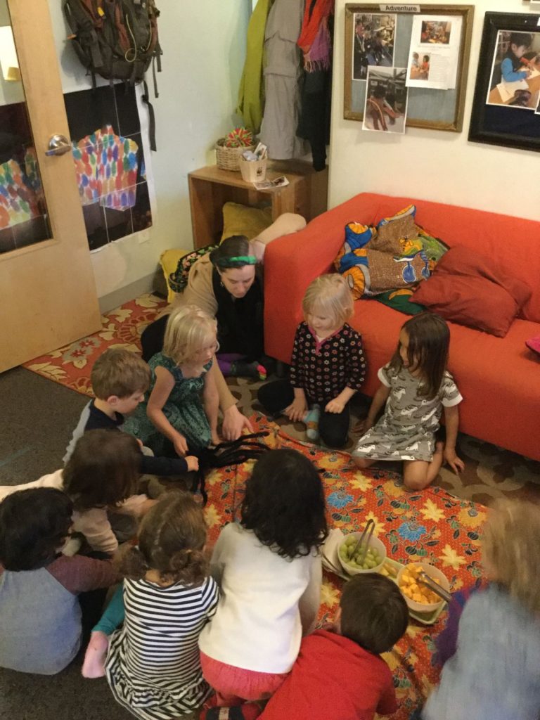 Children watching an electronic spider crawl